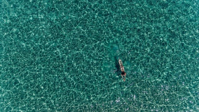 Woman swims in the clear turquoise sea of Sardinia