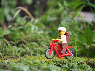 Obraz premium Indonesia - May 14, 2022 : Toys figure and unfocus green grass on the land. Background is blurred and bokeh.