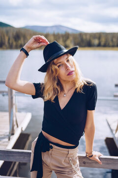 Sweden, Lapland, portrait of fashionable blond woman wearing black hat standing on jetty