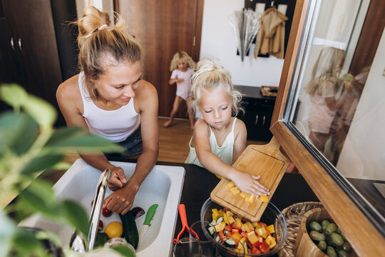 Mother and daughter preparing a salad in the kitchen together
