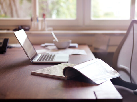 Magazine and laptop on desk