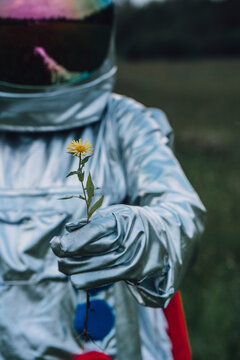 Spaceman holding flower, watching it grow