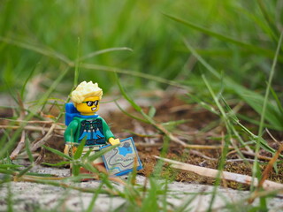 Fototapeta premium Indonesia - November 27, 2019 : Mini toy of action figure at grassland with blurred background. Toy photography concept. Adventure man at grass land conceptual design.