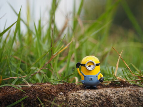 Indonesia - November 11, 2019 : Mini toy of action figure at outdoor with blurred background. Toy photography concept design. Minifigure of Minions character from Despicable Me cartoon film at garden.