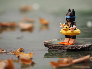 Fototapeta premium Indonesia - November 16, 2018 : Mini toy of action figure at outdoor with blurred background. Toy photography concept design. Batman character from DC Comics film with inflatable rubber.