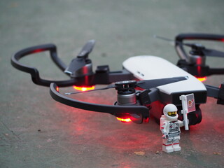 Fototapeta premium Indonesia - June 12, 2019 : Mini toy of action figure at outdoor with blurred background. Miniature photography concept design. Minifigure of pilot astronaut with drone plane.