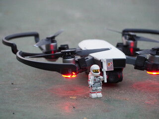 Fototapeta premium Indonesia - June 12, 2019 : Mini toy of action figure at outdoor with blurred background. Miniature photography concept design. Minifigure of pilot astronaut with drone plane.