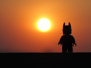 Fototapeta premium Indonesia, 26 July 2019. Gorgeous panorama of the sunset with orange sky and the silhouette lego figure. Enjoying relaxing the sunset.