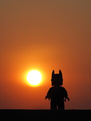 Fototapeta premium Indonesia, 26 July 2019. Gorgeous panorama of the sunset with orange sky and the silhouette lego figure. Enjoying relaxing the sunset.