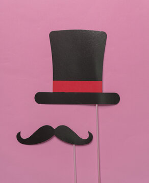 Carnival photo booth hat and mustache on pink background