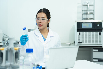 Fototapeta premium Lab work, scientists holds a test tube takes the test from a test tube in analysis for vaccine development.