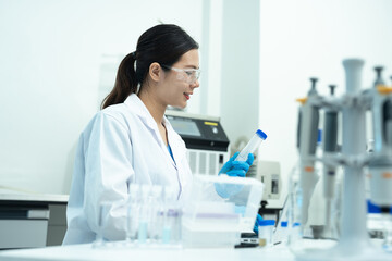 Fototapeta premium Lab work, scientists holds a test tube takes the test from a test tube in analysis for vaccine development.