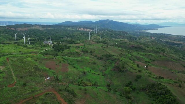 Cinematic aerial footage of Pililla Wind Farm in Rizal, Philippines showing renewable energy wind turbines across green mountain landscapes and tropical countryside.