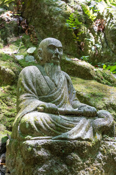 Monk statue in serene Mitaki-Dera temple garden in Hiroshima