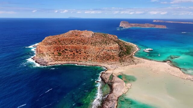 High angle drone photo of Balos beach lagoon with turquoise shallow water, white sand and peninsula in Crete, Greece on a bright sunny summer day.
