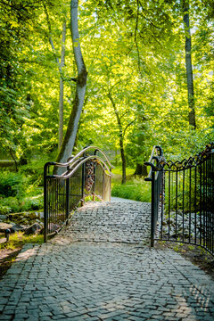 A charming stone bridge in a lush green park surrounded by trees