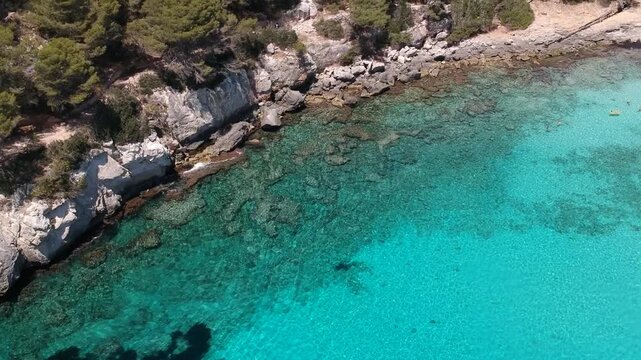 Rocky Coastline and Crystal Clear Turquoise Sea Aerial Drone View of Cala Macarella Menorca Spain