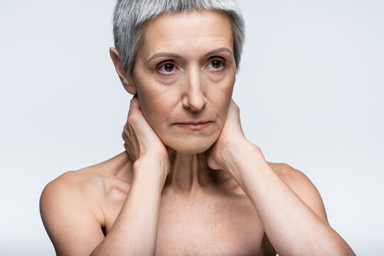 Senior woman with short hair embracing beauty and self care in a serene setting