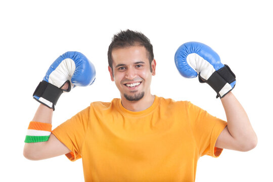 Portrait of happy young man wearing boxing gloves over white background 