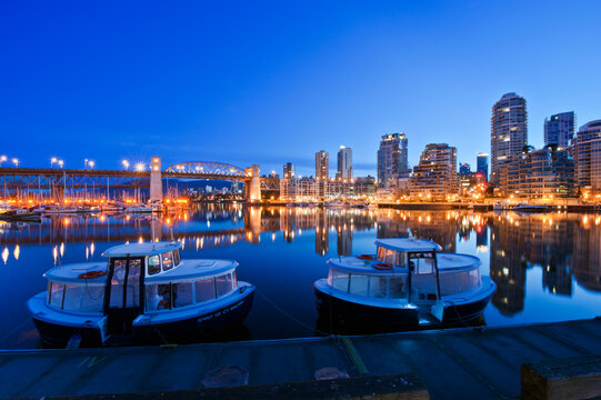Vancouver Skyline Granville Island waterfront, reflected in the flat calm waters of False Creek at dawn