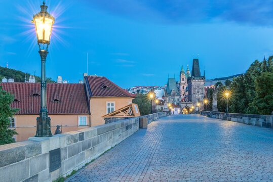 The Charles Bridge at dawn, a cobbled roadway and parapet and view of the old town.