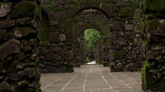Vasai, Maharashtra, India - July 30, 2026: Rain-soaked corridor inside the historic Vasai Fort surrounded by lush tropical vegetation during the annual monsoon.