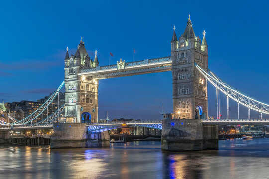 The Tower Bridge crossing the river Thames, the lifting bridge over the water, lit up at night.