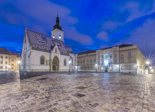 Zagreb, St. Mark's Square at Dawn, historic buildings and a small church and bell tower.