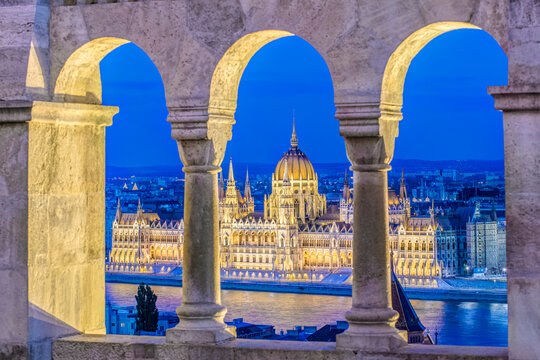 Budapest, the Hungarian Parliament building, Orsz&aacute;gh&aacute;z, neo-Gothic architecture, dome and stone pinnacles, lit up at dusk, by the River Danube, elevated view from the Fisherman's Bastion.