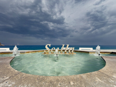 Fountain and Sign for the Town of Scilla with a sea view.