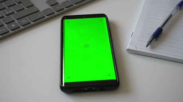 Smartphone with green screen chromakey on desk.