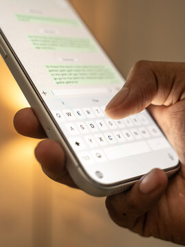 Man hands chatting and typing on smartphone macro closeup.
