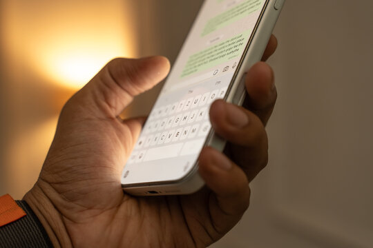 Man hands chatting and typing on smartphone macro closeup.