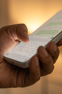 Man hands chatting and typing on smartphone macro closeup.
