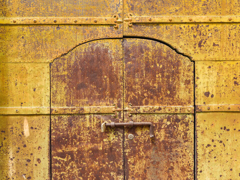 Weathered Metal Door with a large bolt locking mechanism.