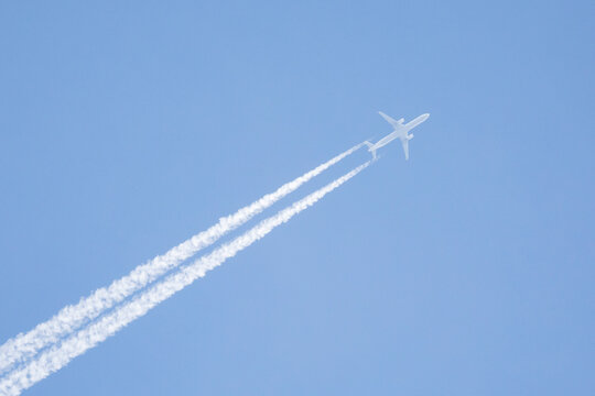 Jet Plane leaving vapour con trails across a blue sky,