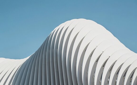 Modern architectural building facade. Abstract white curves against a clear blue sky.
