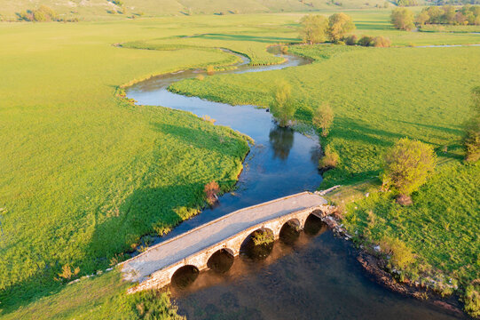 Meandering Suica River in the Duvanjsko Polje, the Duvno field valley, view from overhead, the Roman bridge.