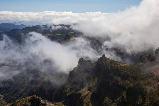 View from Pico de Areeiro, the mountain peak in the middle of the island of the surrounding peaks and valleys, mist and cloud rolling in.