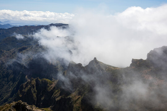 View from Pico de Areeiro, the mountain peak in the middle of the island of the surrounding peaks and valleys, mist and cloud rolling in.