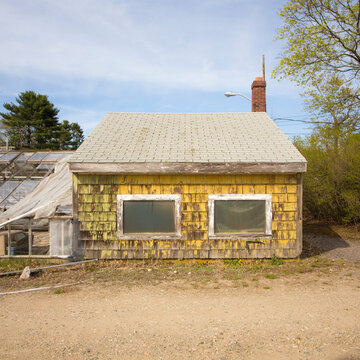 A derelict farmhouse and outbuildings, ripped plastic sheeting, the property demolished in 2015.
