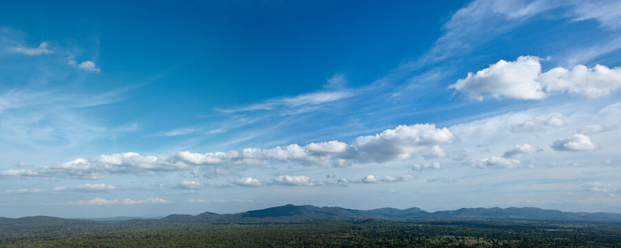 A panorama of sky above small mountains, covered with trees. Sri Lanka