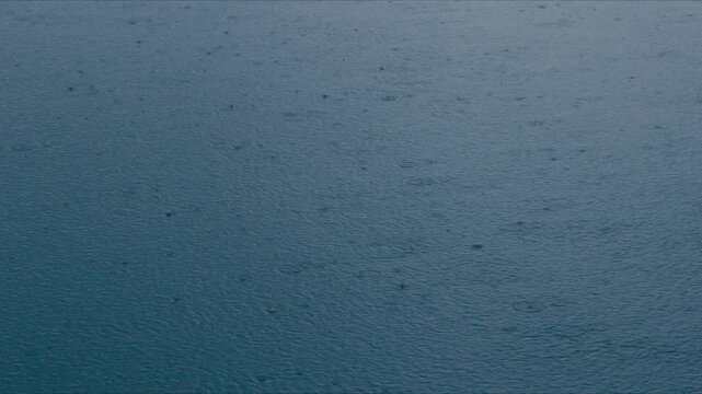 Rain water surface ripple blue texture abstract droplet wave pond pattern wet background calm mood storm weather nature aquatic scene dark climate impact weather background