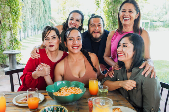 group of friends or multi generation family eating and having a dinner in a terrace party in Mexico Latin America, hispanic diverse and multicultural people in a restaurant