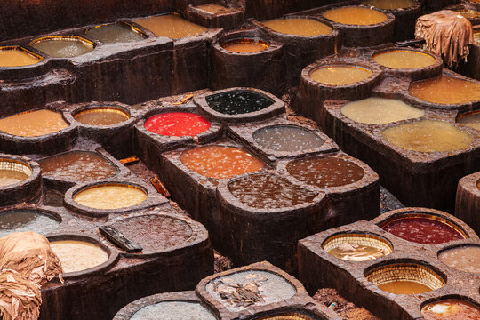 Tannery, elevated view of the dye pits with coloured liquid and submerged animal hides curing.