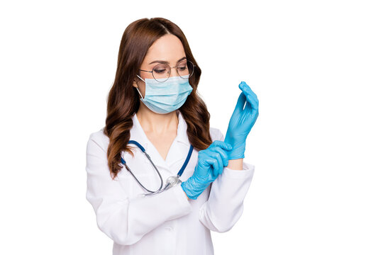 Photo of beautiful doc lady ready for operation young professional surgeon take on latex gloves wear glasses protective flu mask stethoscope white lab coat isolated grey color background