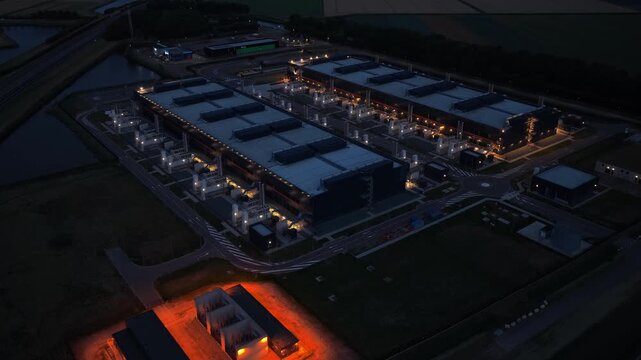 Aerial view of a large data center at night, with lights indicating data processing. Concept of cloud computing, big data and ai