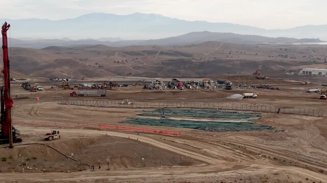 The drone orbits at low altitude and slowly glides along side the El Sobrante Land Fill revealing a network of large trucks and heavy equipment working diligently to contain and control area garbage.