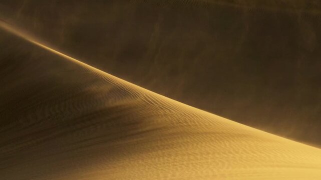 Strong wind blowing sand over dune ridge in desert at sunset, golden sandstorm sweeping across desert dune in warm light. Sand dune ridge in desert with sand blowing in strong wind. Sandstorm