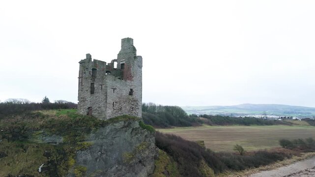 Drone cranes up revealing Greenan Castle ruins above Greenan Shore, Ayr.